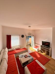 a living room with a couch and a tv at Bjelasnica Apartment with the most beautiful view in Bjelašnica