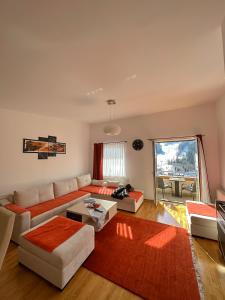 a living room with a couch and a table at Bjelasnica Apartment with the most beautiful view in Bjelašnica