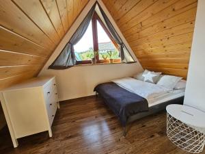 - une chambre avec un lit et une fenêtre mansardée dans l'établissement Panorama Szymaszkowa, à Zakopane