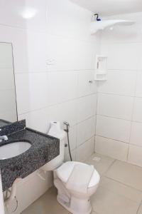 a bathroom with a toilet and a sink at Hotel Grandville III in Palmeira dos Índios