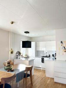 a kitchen with white cabinets and a table and chairs at 46m2 Studio in Rovaniemi