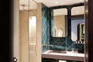 uma casa de banho com um lavatório e um espelho em Hotel Indigo Berlin - East Side Gallery em Berlim