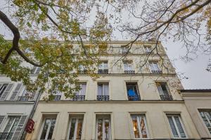 - un grand bâtiment avec des fenêtres sur le côté dans l'établissement Résidense au coeur de Paris by Studio prestige, à Paris