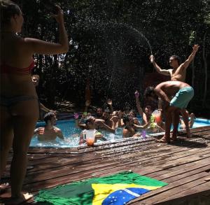 grupa ludzi bawiących się w basenie w obiekcie Lagarto Na Banana Hostel w mieście Pipa