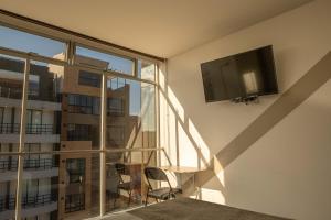 Habitación con TV en la pared y ventana en Hotel Wess en Bogotá