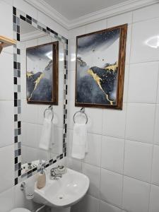 a white bathroom with a sink and a mirror at Anka Lodge Quitor in San Pedro de Atacama