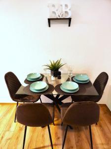 mesa de comedor con sillas y mesa con platos en City Appartement Mönchengladbach, en Mönchengladbach