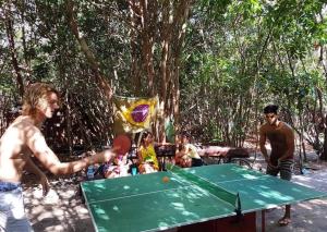 a group of people playing a game of table tennis at Lagarto Na Banana Hostel in Pipa