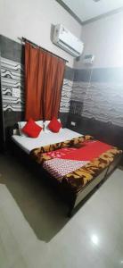 een groot bed met rode kussens in een kamer bij OYO Hotel Rajdeep in Agra