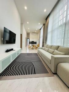 a living room with a couch and a flat screen tv at HomeHug@ChiangRai in Chiang Rai