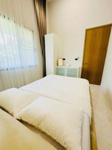 1 Schlafzimmer mit 2 weißen Betten und einem Fenster in der Unterkunft HomeHug@ChiangRai in Chiang Rai