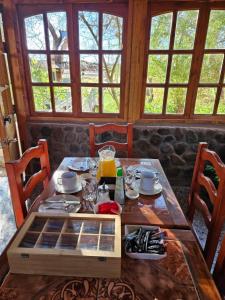 a table in a room with windows and a table with food at Anka Lodge Quitor in San Pedro de Atacama