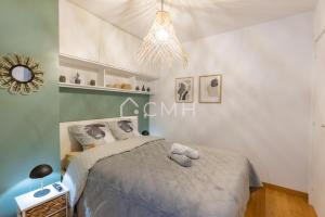 Schlafzimmer mit einem Bett und einem Kronleuchter in der Unterkunft Magnifique appartement à 10 min de l'aéroport Orly in Villeneuve-le-Roi