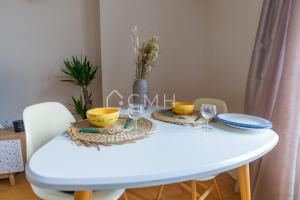 einen weißen Tisch mit 2 Stühlen und einen weißen Tisch mit Brille in der Unterkunft Magnifique appartement à 10 min de l'aéroport Orly in Villeneuve-le-Roi