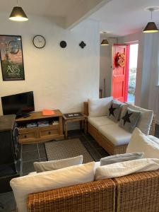 a living room with a couch and a tv at The Potters Cottage in Clifden