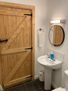 a bathroom with a wooden door and a sink at The Potters Cottage in Clifden +42 photos