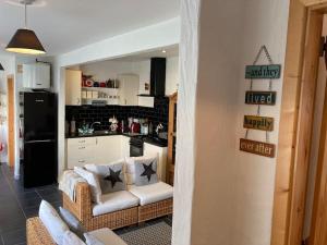 a living room with a couch and a kitchen at The Potters Cottage in Clifden