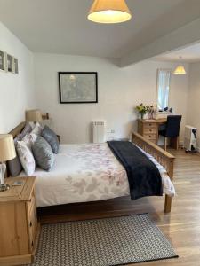 a bedroom with a large bed and a desk at The Potters Cottage in Clifden