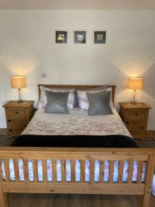 a bedroom with a wooden bed with two night stands at The Potters Cottage in Clifden