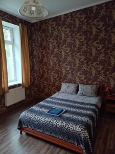 a bedroom with a bed with a book on it at Gostevoy Apartment in Vinnytsya