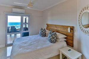 a bedroom with a bed with a view of the ocean at Les Dauphine 3 - Premier Beach Front Apartment in Ballito