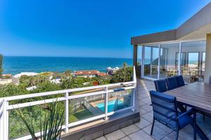 a patio with a table and chairs and the ocean at Les Dauphine 3 - Premier Beach Front Apartment in Ballito