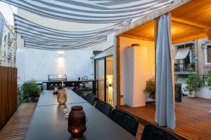 a restaurant with a long table on a balcony at La Palma Barceloneta Penthouse Apartment with Roof Top Terrace in Barcelona
