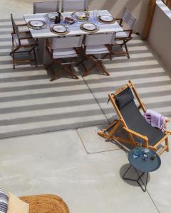 a table and a chair on a patio at Tinos Treasures Apart-Hotel in Istérnia