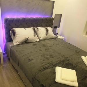 1 dormitorio con 1 cama grande con luz morada en Gas Otel, en Belgrado