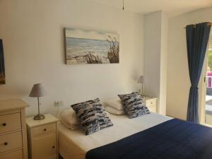 Mojacar Bella - Penthouse - Sleeps 4 - R065 في موجاكار: غرفة نوم بسرير ودهان على الحائط