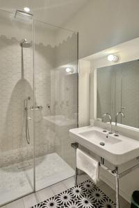 La salle de bains blanche est pourvue d'un lavabo et d'une douche. dans l'établissement Stunning Apartment in City Center, à Vienne