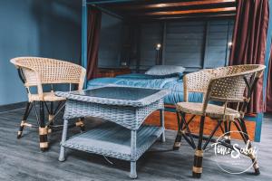 een kamer met 2 stoelen en een tafel en een bed bij Time Sabai 134 in Bangkok