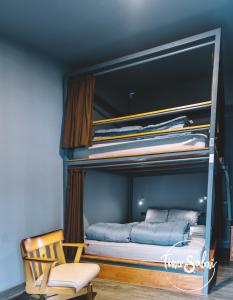 a bedroom with two bunk beds with a chair at Time Sabai 134 in Bangkok
