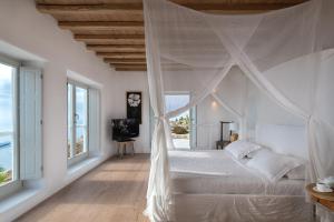 una camera con letto bianco e zanzariera di Villa Montessito Mykonos a Tourlos Altre 27 foto