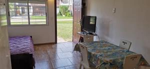 a room with a table and a tv and a bed at La Isla - Araminda in Araminda