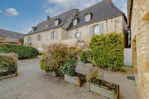 a large stone house with plants in front of it at Gite Monfort in Sainte-Mondane