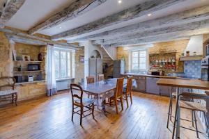 a large kitchen with a wooden table and chairs at Gite Monfort in Sainte-Mondane
