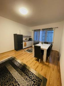 a room with a table and chairs and a kitchen at Fron's Apartment in Pristina