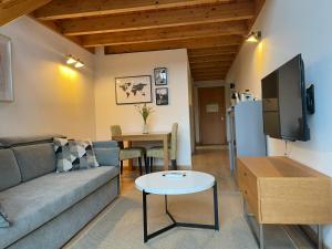 un soggiorno con divano e tavolo di Apartamentos Ciudad Santiago a Santiago de Compostela