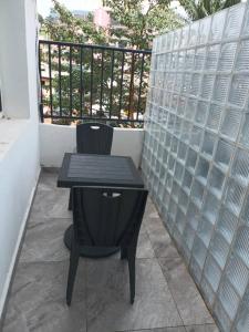 a small black table and chair on a balcony at T2 Cosy Nouvelle Route Bastos Yaoundé in Yaoundé +2 photos