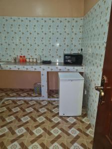 a kitchen with a counter and a refrigerator in a room at Christa's Haven in Siaya