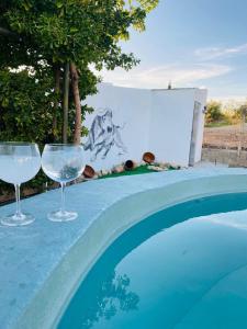 two wine glasses sitting next to a swimming pool at Villa 365 in La Rábita