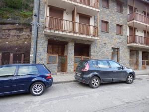dois carros estacionados em frente a um edifício em Pirineos como en casa 2 em Bielsa