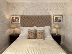 バーフォードにあるBurford Lodge Hotel - Adults onlyのベッドルーム(白い大型ベッド、ランプ2つ付)