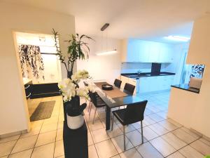 eine Küche und ein Esszimmer mit einem Tisch und Blumen in der Unterkunft Top apartment with 2 bedrooms and fully equiped in Haag