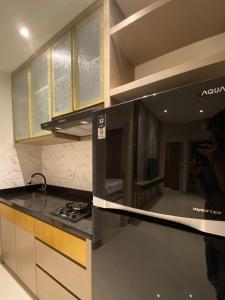 a person taking a picture of a kitchen at Luxury 2BR Benson Apartment, Pakuwon Mall in Surabaya