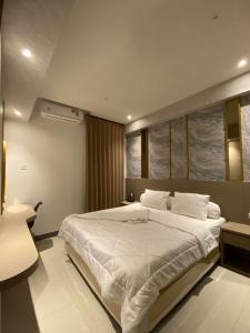 a bedroom with a large white bed and a window at Luxury 2BR Benson Apartment, Pakuwon Mall in Surabaya