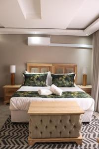 a bedroom with a large bed with two towels at EDEN BOUTIQUE HOTEL in Kokstad