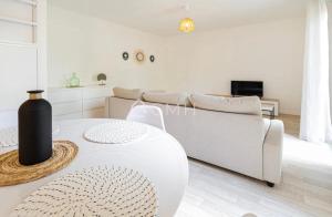 Sala de estar blanca con sofá y mesa en Pascal’s Cosy Retreat, en Rosny-sous-Bois