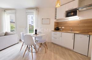 a living room with a table and a kitchen at Pascal’s Cosy Retreat in Rosny-sous-Bois +1 photo